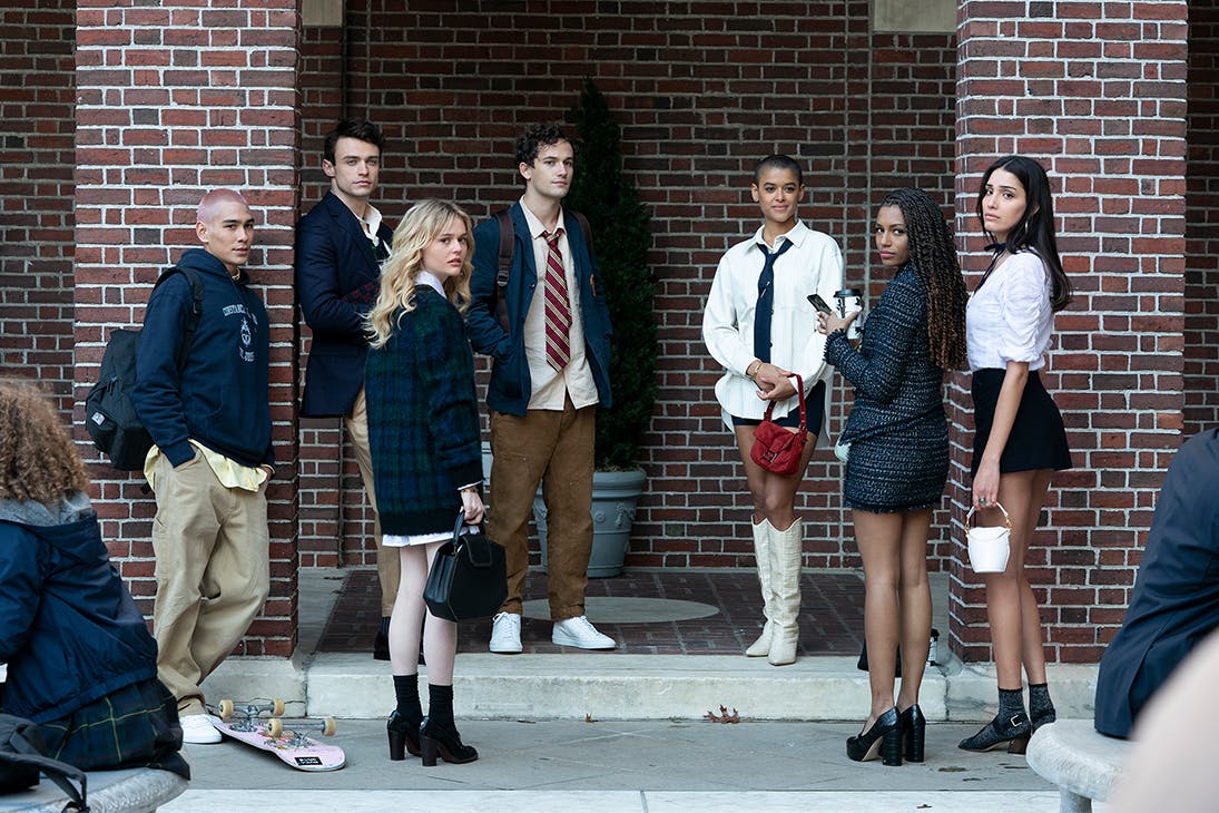 The cast of the Gossip Girl reboot stand on the steps of a brownstone building in New York